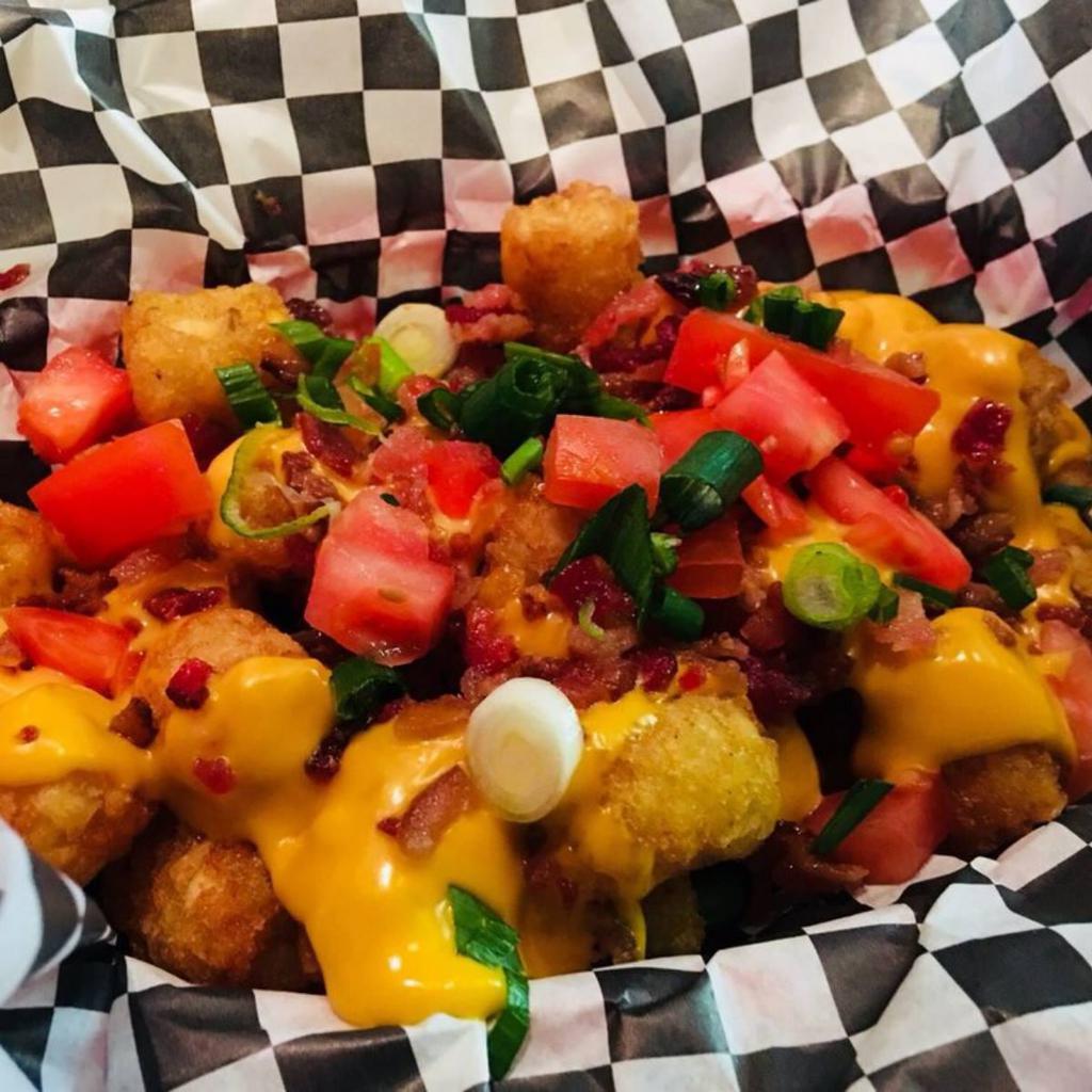 Irish Nachos · Tater tots with queso cheese and bacon bits, topped with tomato, green onion and sour cream. Add ground beef, chicken or chili for an additional charge.