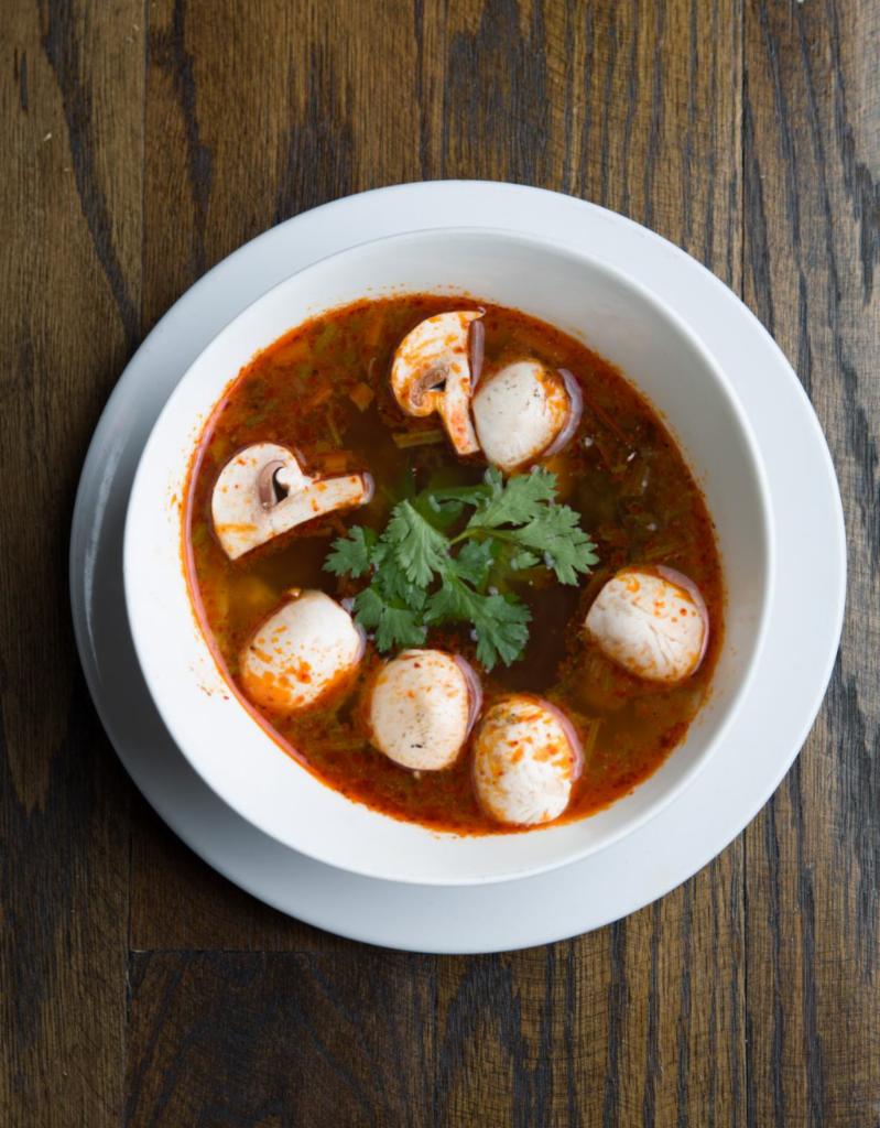 SP1 Tom Yum Soup · A savory spicy and sour soup seasoned with exotic Thai herbs, mushrooms, lemongrass, kaffir leaves, and cilantro.
