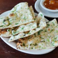 Garlic Naan · Naan bread baked in tandoori clay oven topped with fresh minced garlic and cilantro.