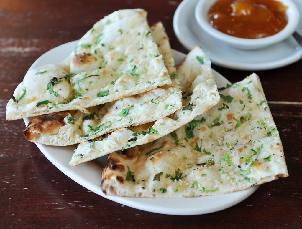 Garlic Naan · Naan bread baked in tandoori clay oven topped with fresh minced garlic and cilantro.