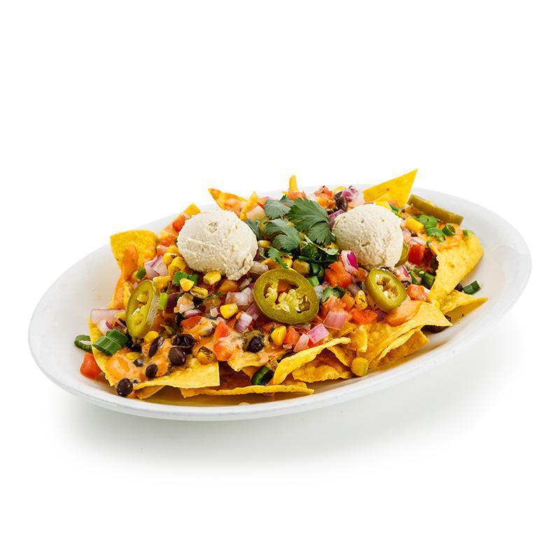 Nachos · Corn tortilla chips, black beans and chipotle sauce, topped with cashew cheese, salsa fresca, roasted corn, green onions, cilantro and pickled jalapeño peppers. Vegan.