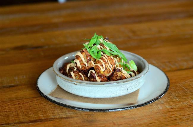 Housemade Loaded Tater Tots · Shredded Potatoes, Pork Croutons, Cheddar Cheese, Chives & Sriracha Cream