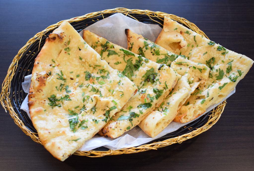 Garlic Naan · Baked to order in our clay oven.