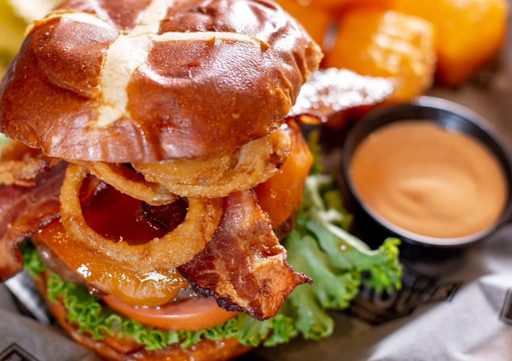Hickory Cheddar Burger · Cheddar cheese, bacon, crispy fried onion straws and honey BBQ sauce. Served on a grilled pretzel bun.