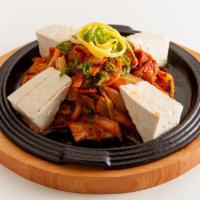 A5. Jeyuk Dubu Kimchi · Marinated pork loin and kimchi stir-fried with hot pepper sauce served with tofu on a hot pl...