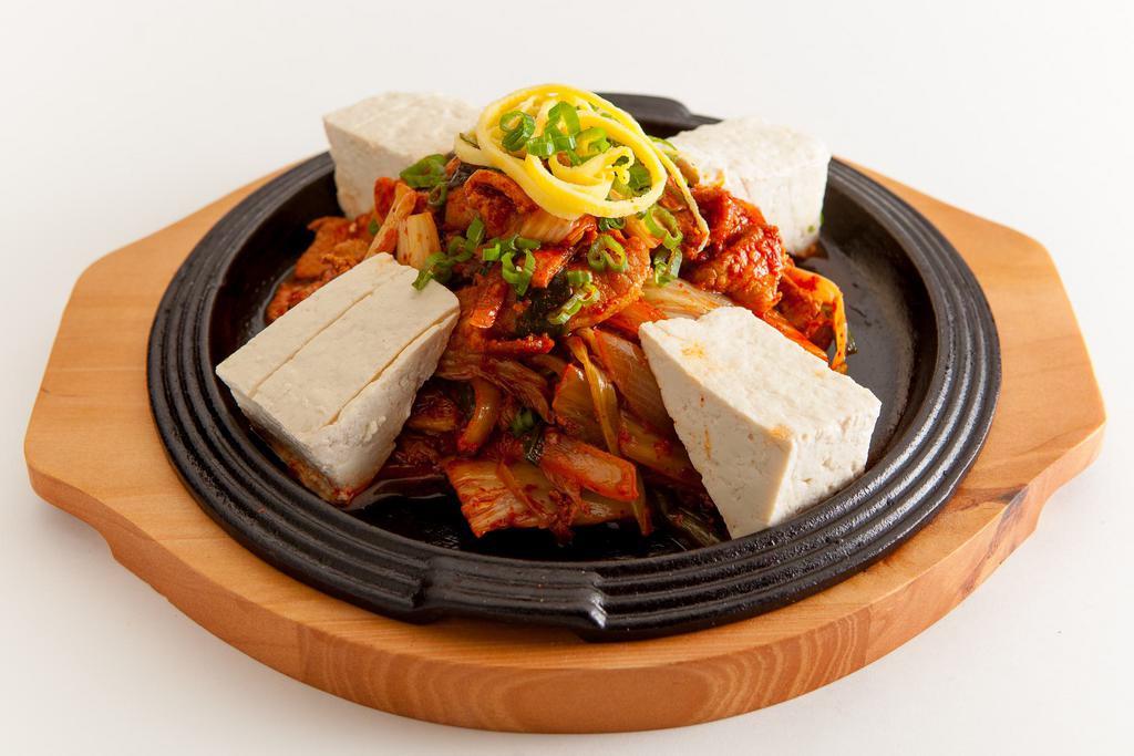 A5. Jeyuk Dubu Kimchi · Marinated pork loin and kimchi stir-fried with hot pepper sauce served with tofu on a hot plate. Spicy.