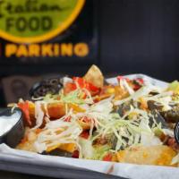 Nachos · House-made tortilla chips piled high with cheese blend, lettuce, corn salsa, guacamole, sour...