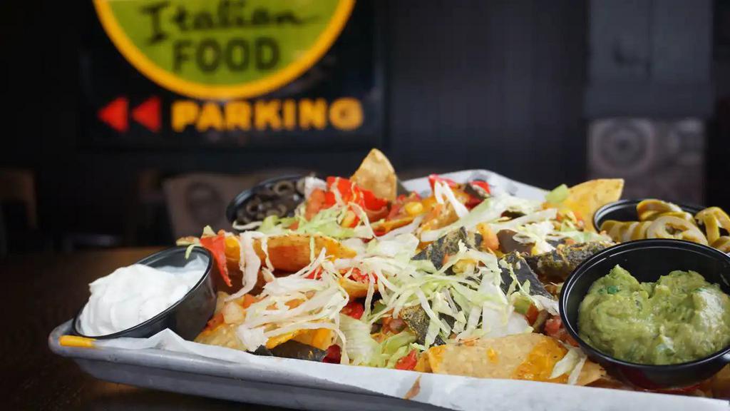 Nachos · House-made tortilla chips piled high with cheese blend, lettuce, corn salsa, guacamole, sour cream black, olives, and a side of jalapenos. Add pulled pork or chicken for an additional charge.