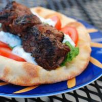 Grilled Lamb Kabab · Tender lamp meat grilled, lettuce, tomatoes, pickles, and tahini sauce.