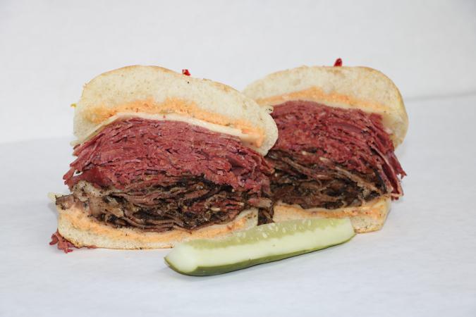 United Meat · Corned beef, pastrami, melted swiss cheese, and Russian dressing on an onion roll.