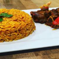 Jollof Rice + Peppered Goat Meat · Rice mixed with red tomato sauce & onions and Goat meat stir fried with peppers and onions.