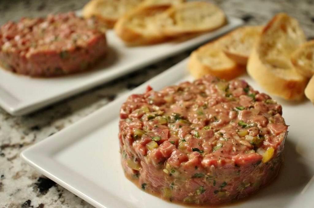 Steak tartare au couteau · Traditional hand chopped seasoned raw grass-fed beef, served croutons