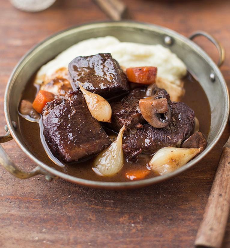 Boeuf Bourguignon · Slowly braised Angus beef stew with carrots, pearl onions, mushrooms, bacon served with mashed.