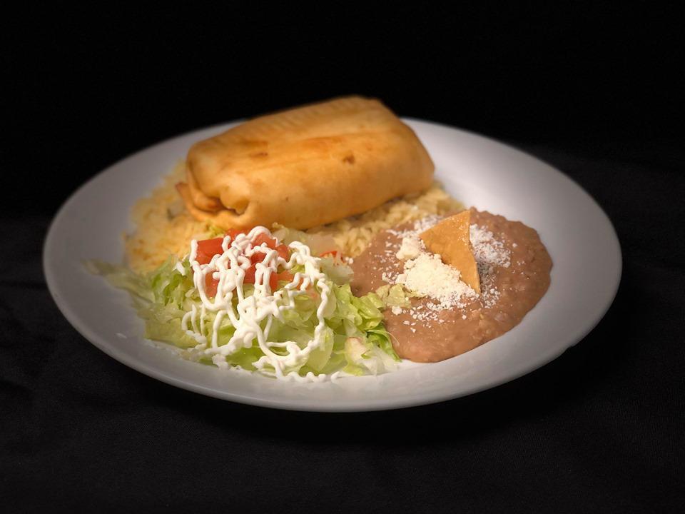 Chimichanga Supreme · Flour tortilla, queso Oaxaca, rice, black beans, stuffing of choice, lettuce and tomatoes.