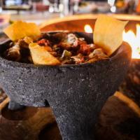 Molcajete · Your choice of chicken or steak sauteed with sweet peppers, onions, and mushrooms in roasted...