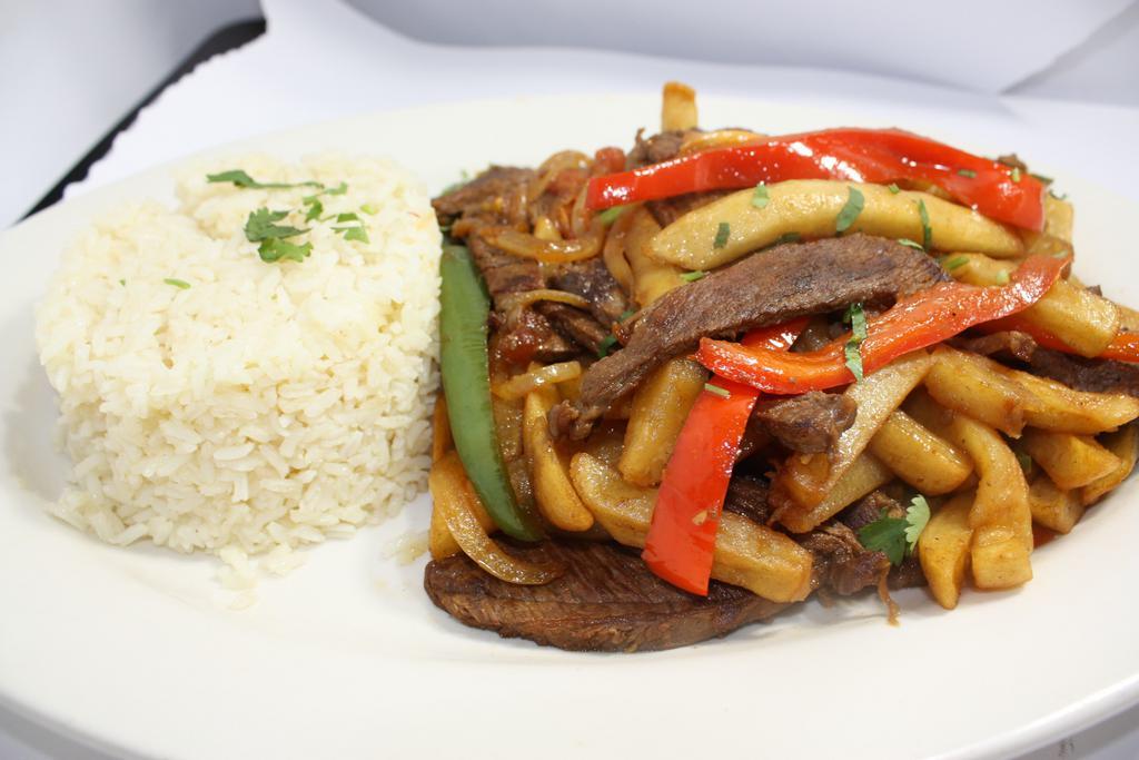Lomo Saltado de res · Comes with white home made rice and vegetable with french fries.