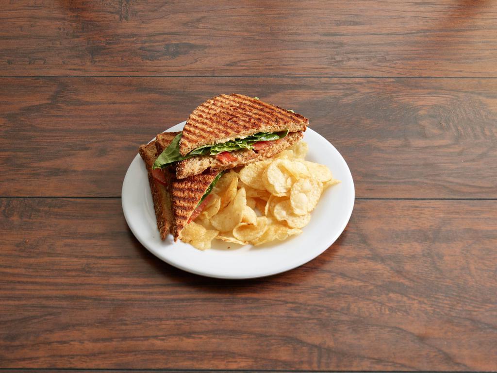 Grilled TLT Panini · Our version of the BLT. Smoked tempeh, tomatoes, lettuce and vegan cheese on grilled wheat bread. Served with a choice of mixed field greens, lime corn chips or kettle chips.
