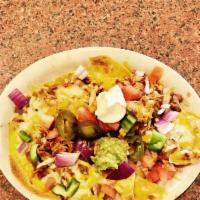 Chicken Nachos · Crispy corn chips and cheese baked to perfection then topped with pulled chicken, beans, sou...