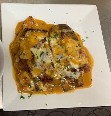 Chicken Sorrentino · Flour battered chicken cutlet topped with sliced prosciutto, sliced eggplant and mozzarella cheese in a Marsala wine sauce.