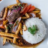 Lomo saltado · Traditional Peruvian favorite! Wok stir-fried beef tenderloin with onions, tomatoes in ginge...