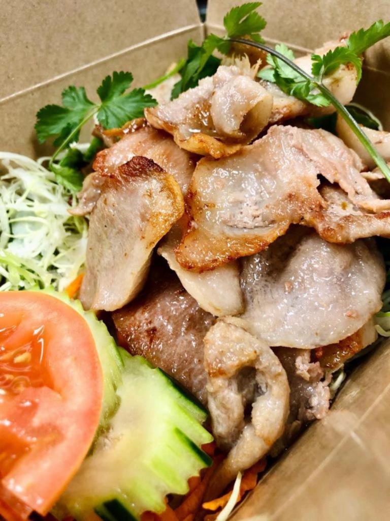 25. Pork Num Tok · Gluten-free. Choice of spice level. Choice of sliced roasted pork with mint, red onions, green onions, cilantro, and ground roasted rice in lime dressing.