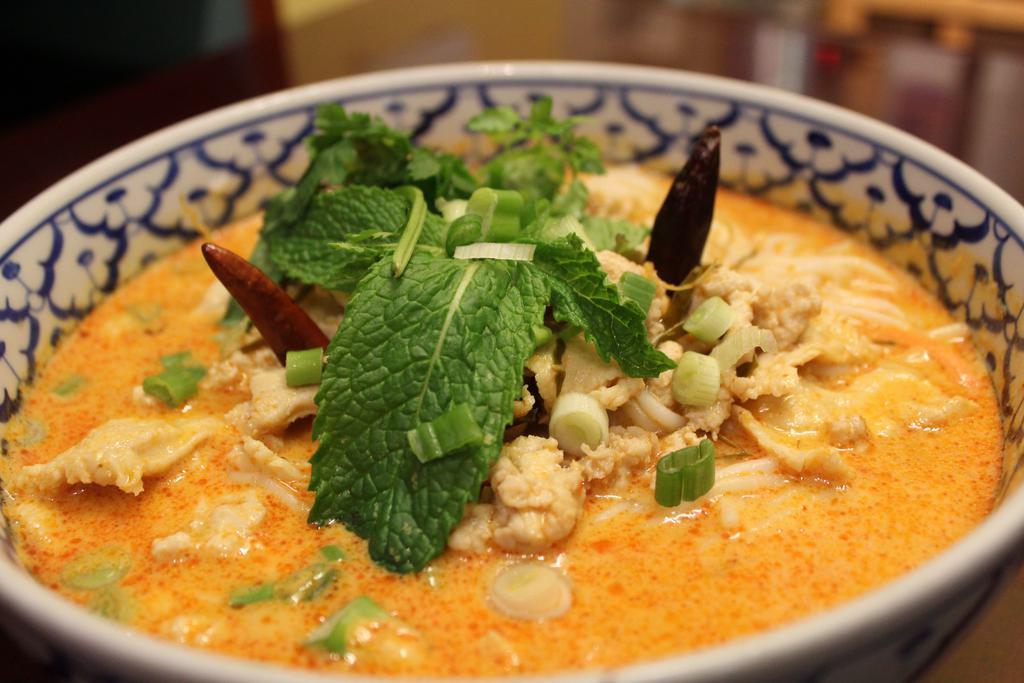 45. Kao Poon · Gluten-free. Choice of spice level. Special red coconut curry soup served with round rice noodles, chicken, shredded cabbage, and bean sprouts.