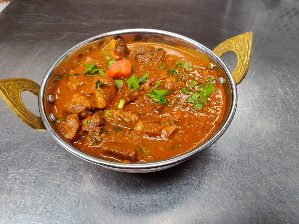 Goat Curry  · Goat meat with bone, traditional dish of Nepal, carefully seasoned with the exotic blend of curry spices, onion, garlic, ginger and tomatoes in a medium-thick sauce