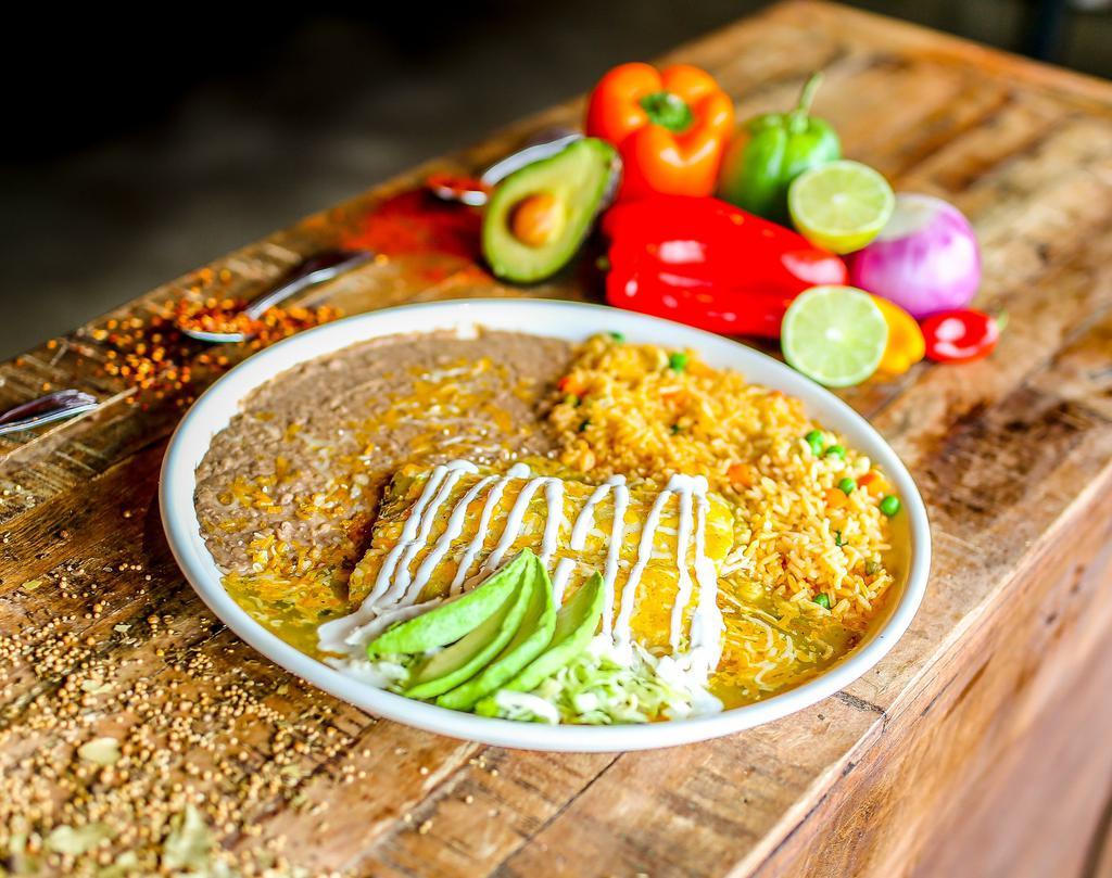 Enchiladas Verdes · Three shredded chicken enchiladas smothered in salsa verde and queso dip. Lettuce, tomatoes, sour cream, and guacamole on the side.