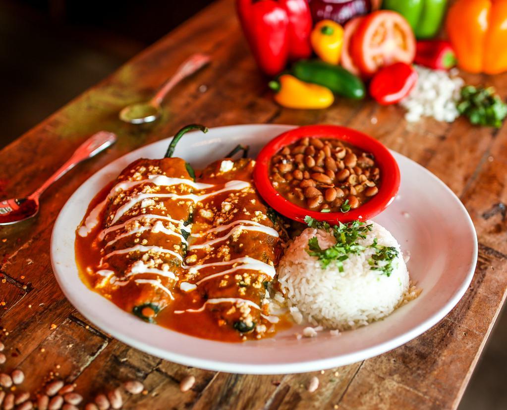 Dos Poblanos · Mild poblano chiles stuffed with jack cheese, shredded chicken, smothered with red sauce and sprinkled with queso fresco. Served with Mexican rice, charro beans and drizzled with Mexican cream.
