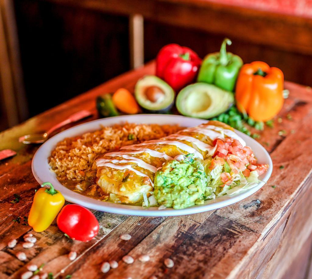 Burrito Al Pastor · Flour tortilla filled with marinated diced pork, Mexican rice, charro beans, pico de gallo, topped with cheese, smothered with green chile, and Mexican crema.