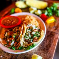 Tacos Al Pastor · Three soft corn tortillas filled with marinated diced pork, topped with fresh pineapple chun...