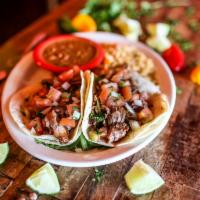 Tacos de Carnitas · Three corn tortillas filled with tender flavorful slow-cooked pork, served with pico de gall...
