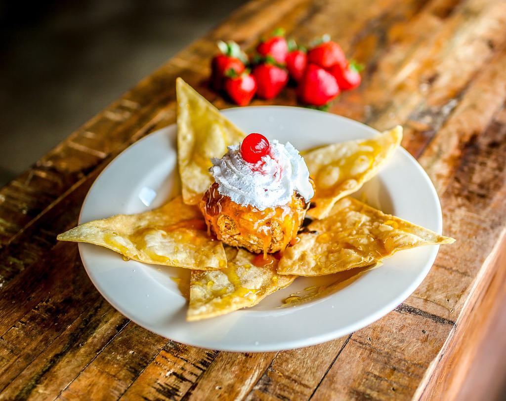 Fried Ice Cream · Vanilla ice cream covered with crispy corn flakes, sweetened with cinnamon and sugar, and then flash fried. Topped with caramel, chocolate syrup, whipped cream, cinnamon crisps, honey and a cherry.