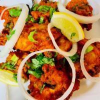 Fish Kolivada · Crispy fish fritters tossed with a blend of aromatic Indian spices and curry leaves.