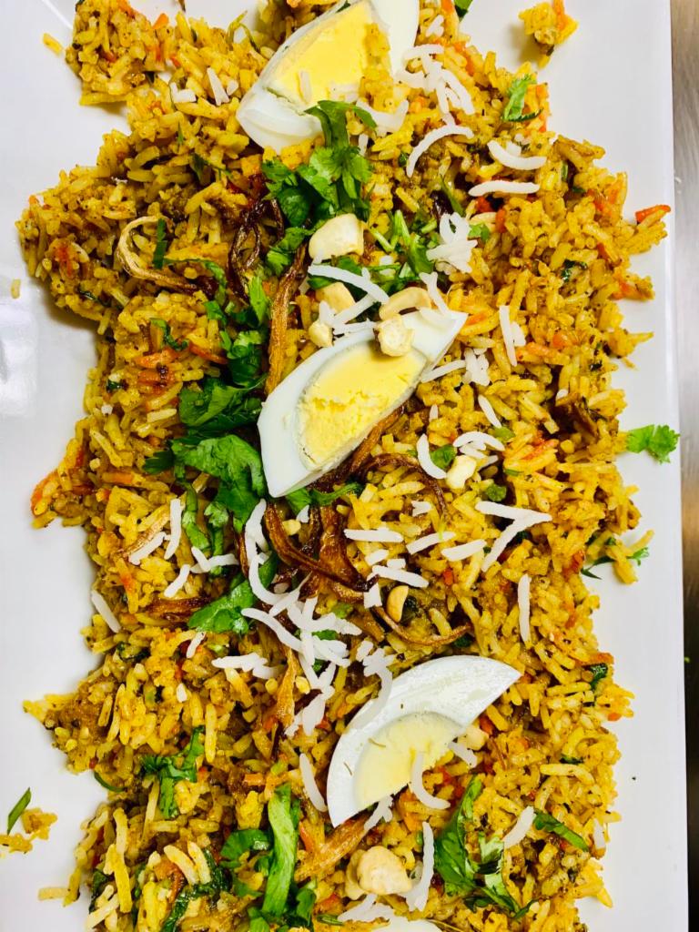 Goat Biryani · Succulent pieces of goat with bone cooked with basmati rice over a low-fire with aromatic Indian herbs and spices.