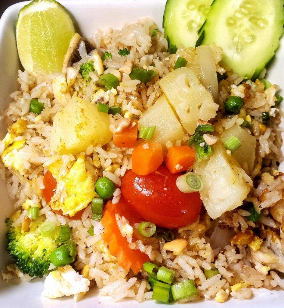 65. Pineapple Fried Rice · Fried rice with egg, cashews, peas, carrots, onion, tomato and pineapple.
