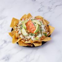 Nachos · Corn tortilla chips topped with refried beans, cheese, sour cream, lettuce, tomato, cilantro...