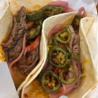 Steak Taco · Shredded filet mignon, cheddar cheese, jalapeno, pickled red onion and Sriracha.