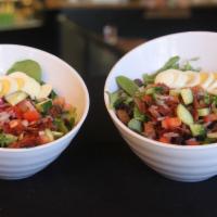 Cobb Salad · Mixed greens, tomato, cucumber and red onion topped with bacon and hard boiled egg with ranc...