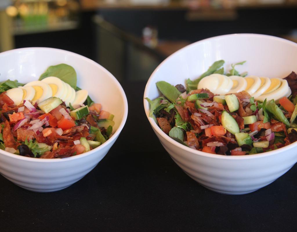 Cobb Salad · Mixed greens, tomato, cucumber and red onion topped with bacon and hard boiled egg with ranch dressing.