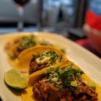 Tacos de Suadero · Bohemia-braised brisket, avocado, red onions, cilantro, tomatillo salsa and horseradish crem...