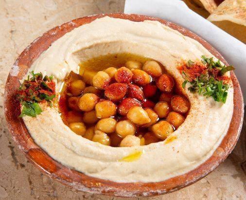Hummus حـمص · A creamy dip of chickpeas, tahini, lemon, and garlic. Topped with olive oil.
