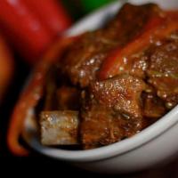 Chivo / Goat · Stewed goat mixed with red and green bell peppers served with two sides 