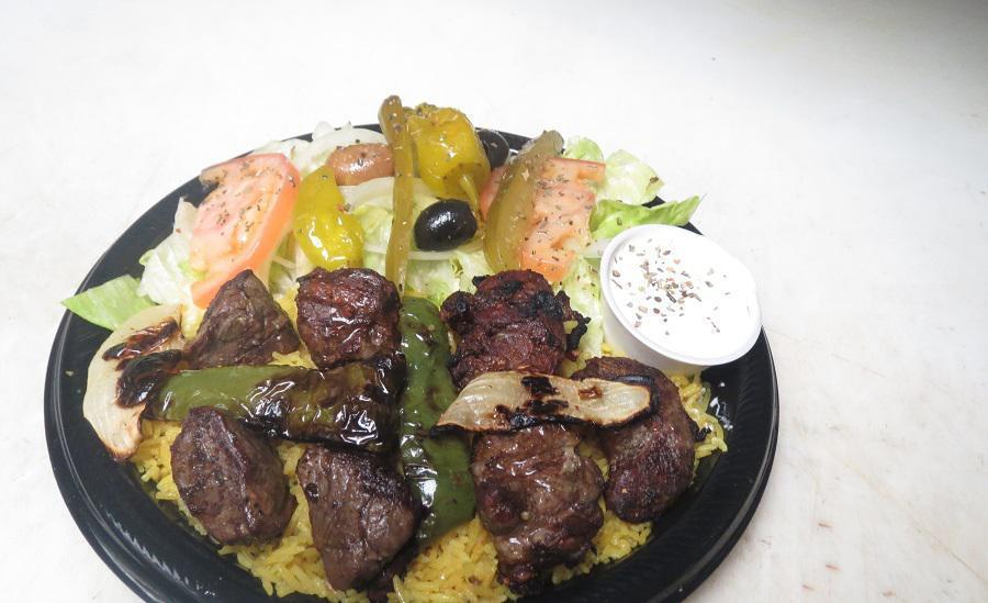 #19 Lamb Shish Kabob · Grilled marinated lamb served on a bed of rice, topped with grilled onions, grilled green pepper, salad with pita bread and cucumber sauce.