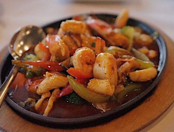 Seafood Hot Plate · An array of bay scallops, shrimp, crab and squid and a scattering of vegetables bathed in spicy red chilli sauce and served in sizzling steel plate.