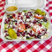 Greek Salad · A large salad with lettuce, tomato, red onion, black olive, beets, feta cheese, and pepperon...