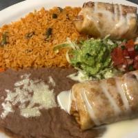 28. Chimichanga · 2 crispy burritos with chicken or beef fillings covered with cheese sauce. Served with lettu...