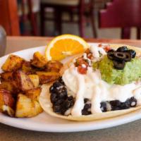 Huevos Rancheros Breakfast · 2 poached eggs over grilled corn tortillas with black beans, Jack cheese, housemade salsa, s...