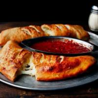 Calzone · Ricotta & mozzarella cheese, spices & fresh garlic baked in pizza dough, brushed with garlic...