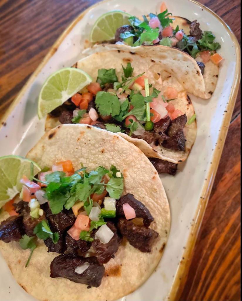 Tejas Street Tacos · 3 KC steak tacos topped with onions and cilantro. Served with limes and 2 sides. Add pico and cheese for an additional charge.